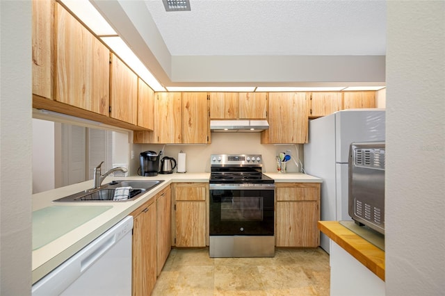 kitchen with a sink, white appliances, a textured ceiling, and under cabinet range hood