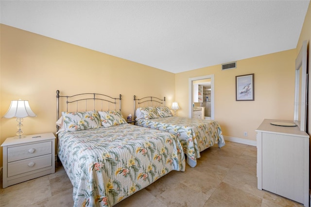 bedroom featuring visible vents, ensuite bath, and baseboards