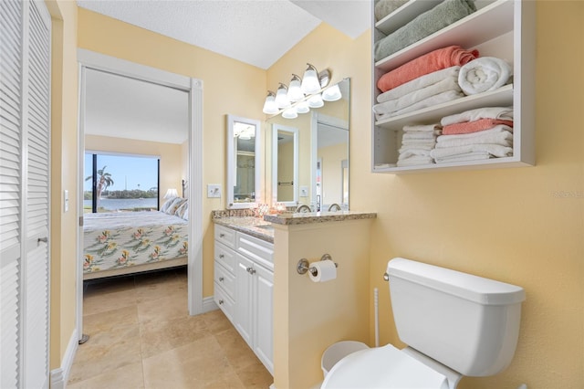 bathroom featuring a closet, tile patterned floors, toilet, and vanity