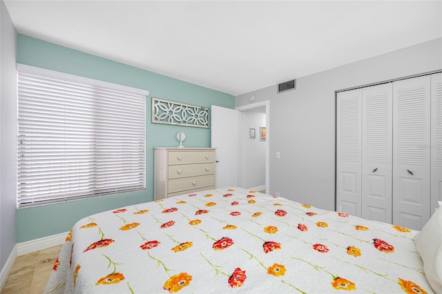 bedroom with a closet, visible vents, and baseboards