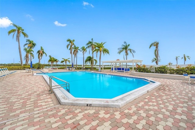 pool with a patio area and a pergola