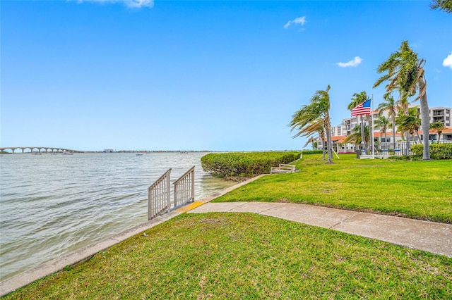 view of dock with a yard and a water view