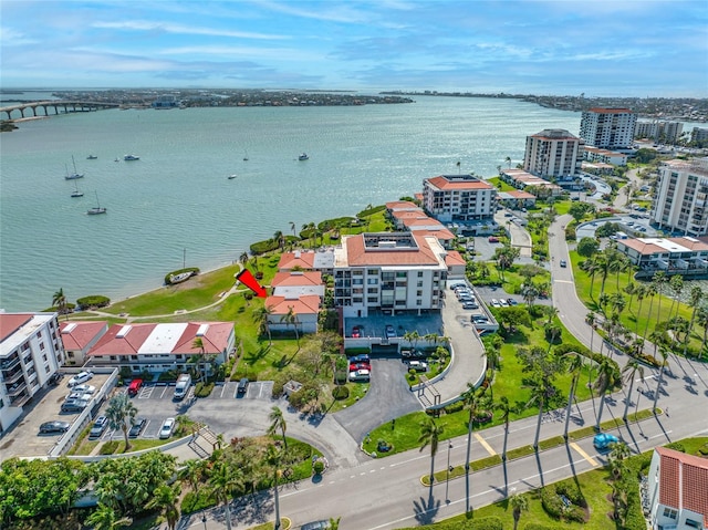 drone / aerial view featuring a city view and a water view