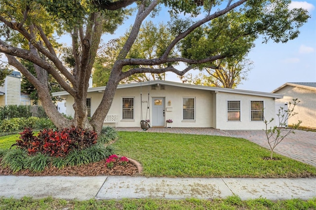 view of front of home with stucco siding and a front yard