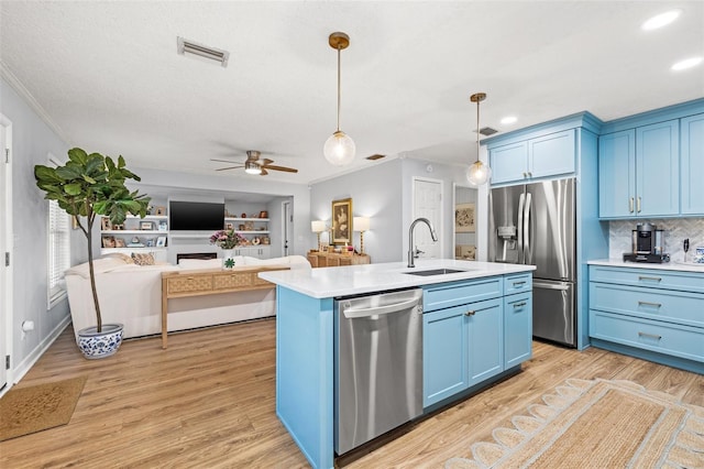 kitchen featuring blue cabinetry, light countertops, appliances with stainless steel finishes, a ceiling fan, and a sink