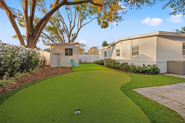 view of yard featuring an outbuilding, a storage unit, and a fenced backyard