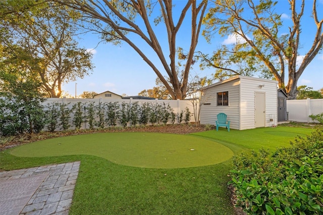 view of yard featuring a storage shed, an outbuilding, and a fenced backyard