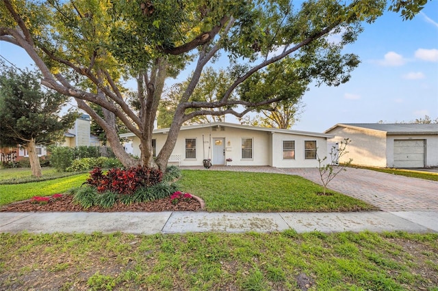 view of front of property with decorative driveway, a front yard, and stucco siding