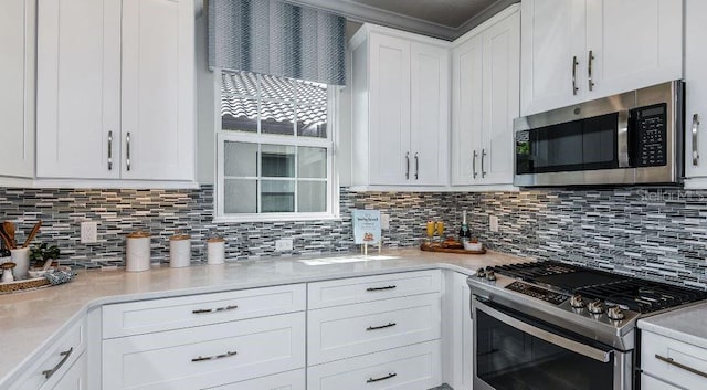 kitchen featuring light countertops, white cabinets, backsplash, and appliances with stainless steel finishes