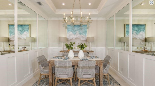 dining space with an inviting chandelier, a raised ceiling, a decorative wall, and visible vents