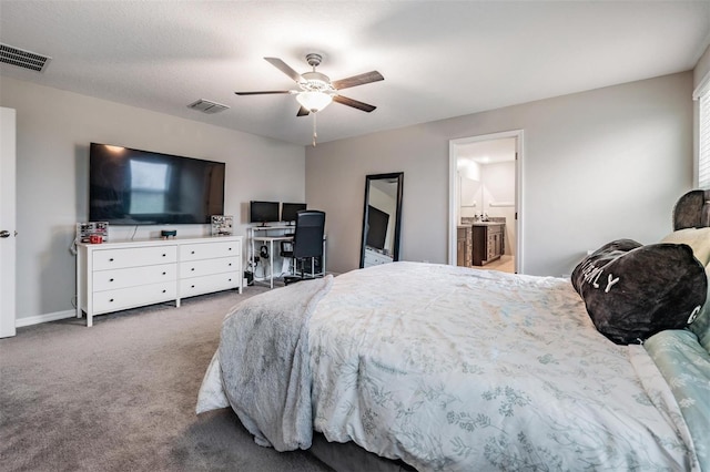 carpeted bedroom featuring visible vents, baseboards, ensuite bath, and ceiling fan