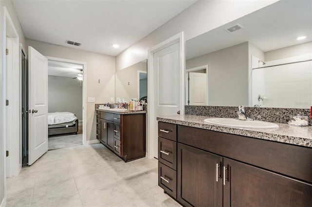 bathroom featuring visible vents, ensuite bathroom, two vanities, and a sink