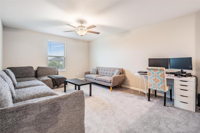 carpeted living room featuring a ceiling fan and baseboards