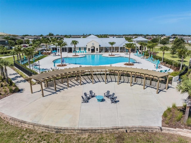 community pool with a patio area and fence