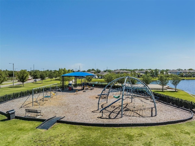 communal playground featuring a water view, a yard, and fence