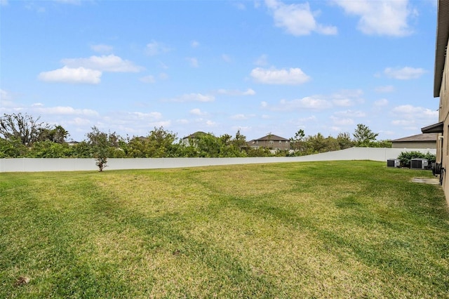 view of yard featuring central AC unit and fence