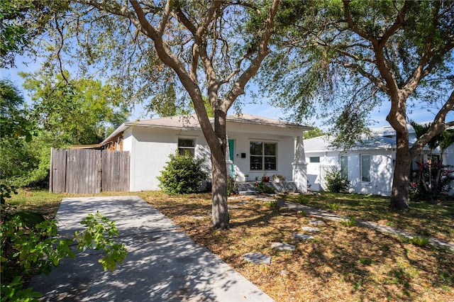 view of front of property featuring concrete block siding and fence