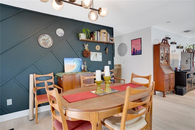 dining space with visible vents and light wood-style flooring