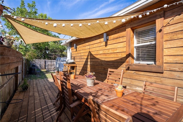 deck with outdoor dining area and a fenced backyard