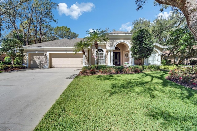 view of front of house with a garage, stucco siding, driveway, and a front lawn