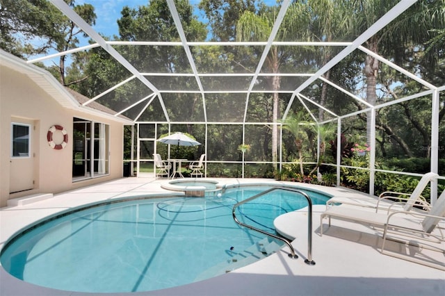 view of pool with a pool with connected hot tub, a lanai, and a patio area