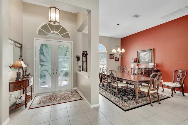 entrance foyer featuring visible vents, a notable chandelier, french doors, tile patterned flooring, and baseboards