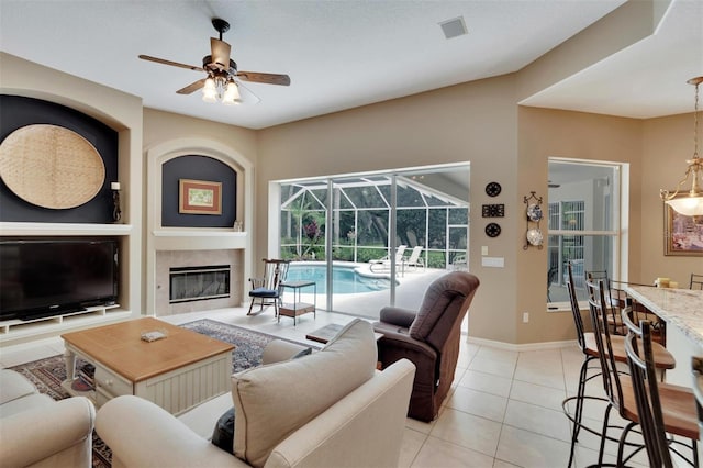 living room with light tile patterned floors, baseboards, visible vents, a sunroom, and ceiling fan