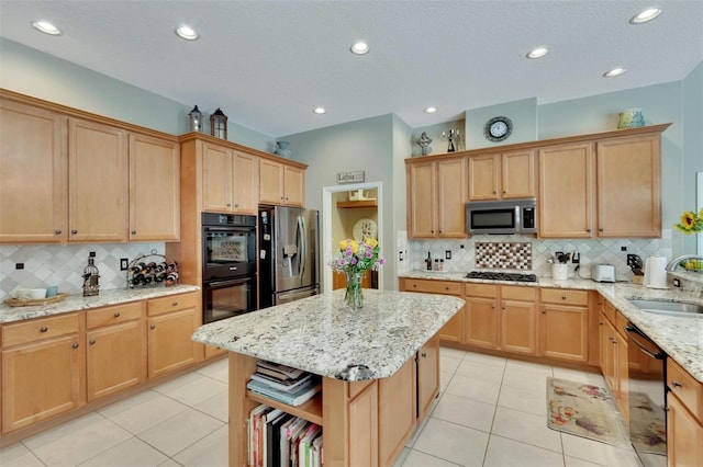 kitchen featuring black appliances, light stone counters, light tile patterned flooring, and a sink