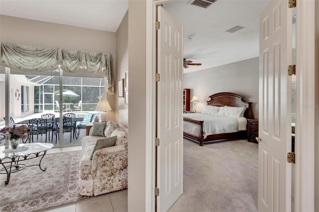 carpeted bedroom featuring tile patterned flooring, visible vents, and a sunroom