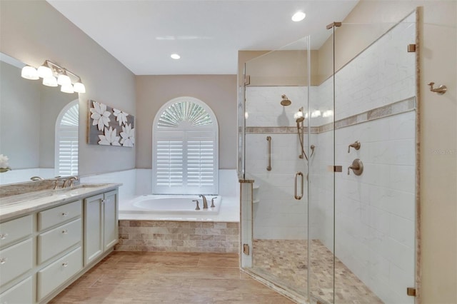 bathroom featuring vanity, a shower stall, a bath, and a healthy amount of sunlight