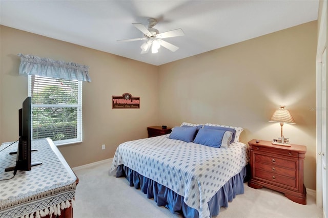 bedroom with light carpet, a ceiling fan, and baseboards