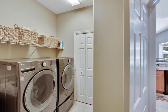 laundry room with light tile patterned floors, laundry area, and washer and clothes dryer