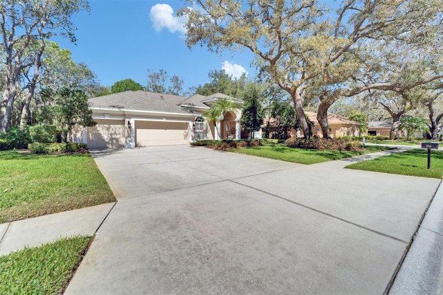 view of front of property with stucco siding, driveway, a front lawn, and an attached garage