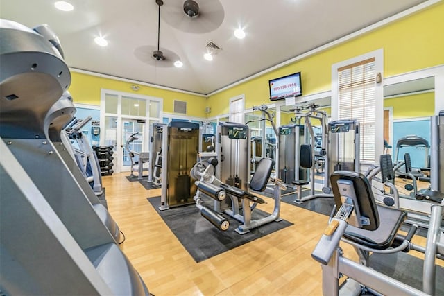 workout area with a ceiling fan, plenty of natural light, wood finished floors, and visible vents