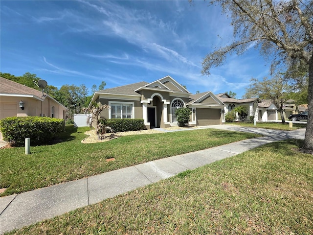 view of front of home with a front yard, fence, an attached garage, stucco siding, and concrete driveway