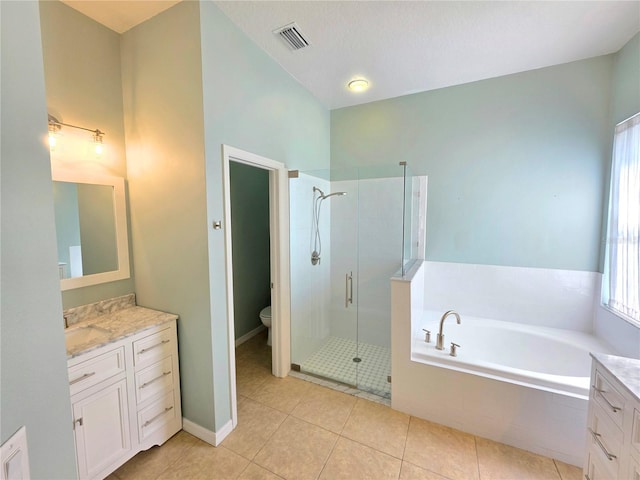 bathroom with a bath, tile patterned flooring, a stall shower, and vanity