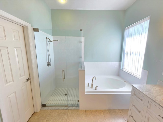 bathroom featuring tile patterned flooring, a bath, vanity, and a stall shower