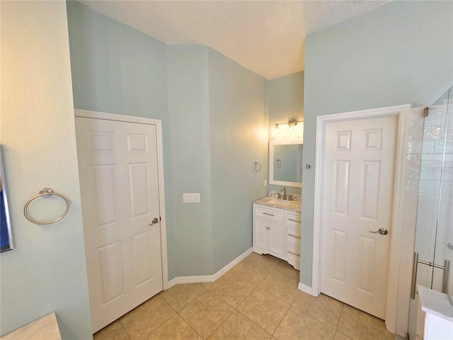 full bath featuring vanity, tile patterned floors, and baseboards