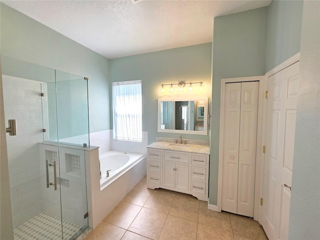 full bathroom with vanity, a shower stall, a textured ceiling, a garden tub, and tile patterned floors