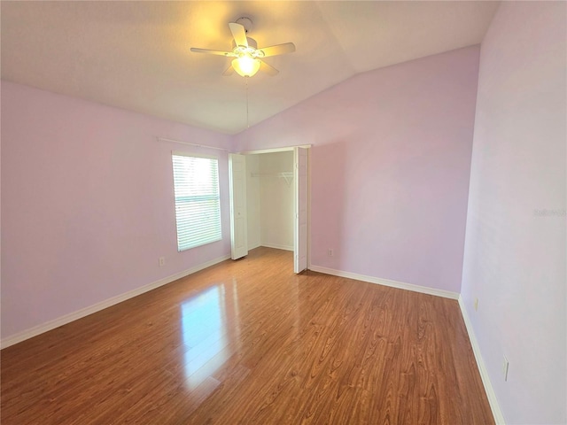 unfurnished room with ceiling fan, baseboards, lofted ceiling, and wood finished floors