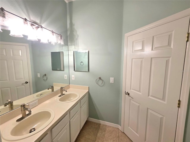 bathroom featuring a sink, baseboards, and tile patterned flooring