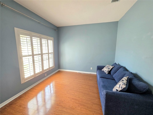 living area with visible vents, wood finished floors, and baseboards