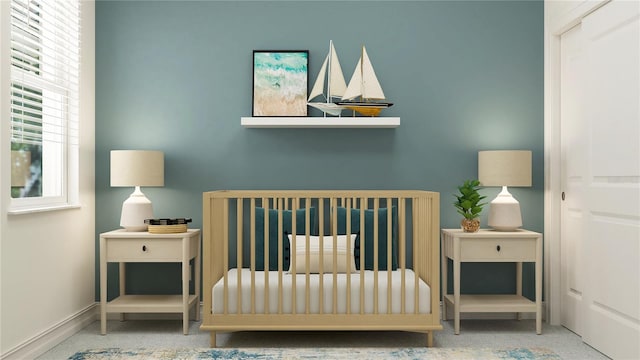 carpeted bedroom featuring a crib and baseboards