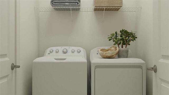 clothes washing area with washing machine and clothes dryer and laundry area