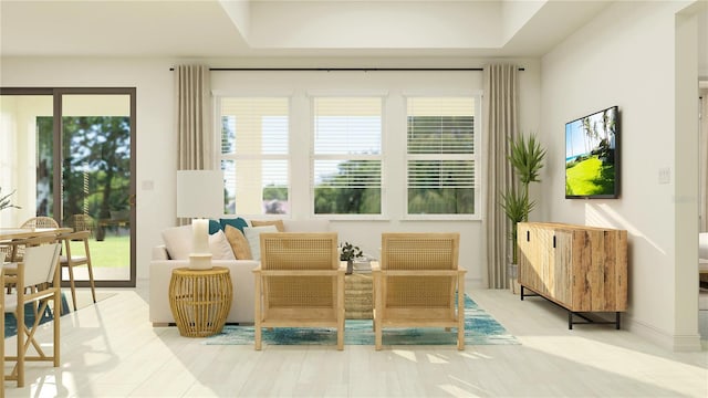 sitting room with a tray ceiling and baseboards