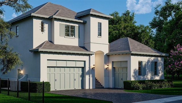 view of front facade featuring stucco siding, decorative driveway, a garage, and fence