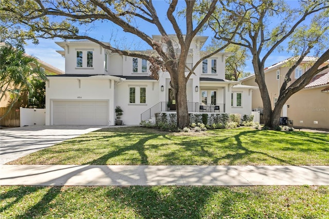 view of front of house with stucco siding, a front lawn, concrete driveway, and an attached garage