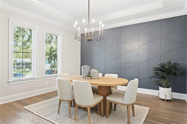 dining room with crown molding, baseboards, an accent wall, dark wood finished floors, and a notable chandelier