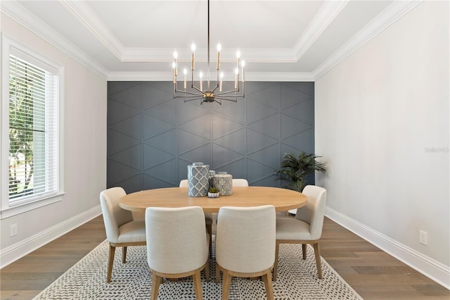 dining room with baseboards, an inviting chandelier, wood finished floors, and an accent wall