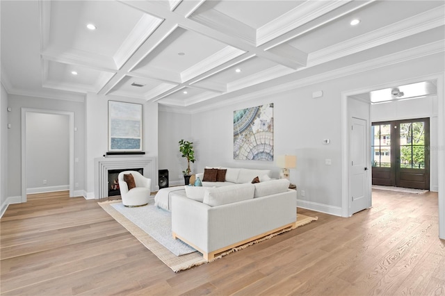 living area featuring beam ceiling, coffered ceiling, light wood-type flooring, and baseboards